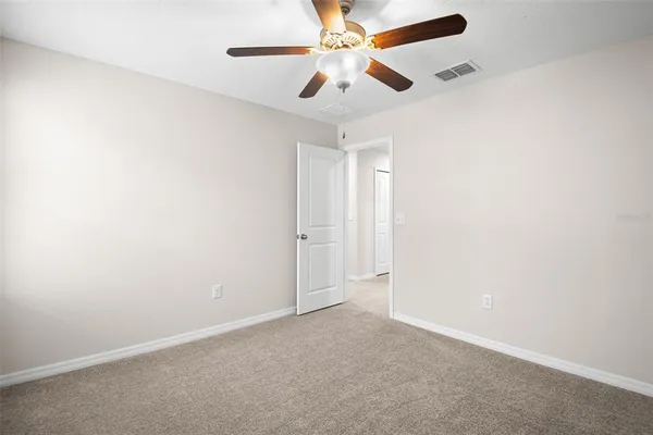 an empty room with a window and a fan