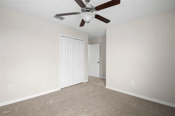 an empty room with a ceiling fan and a window