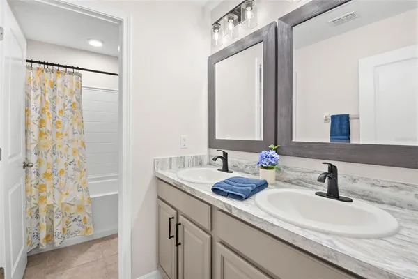 a bathroom with a double vanity sink and a mirror