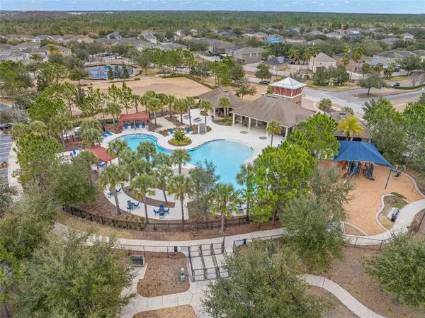 an aerial view of residential houses with outdoor space and trees