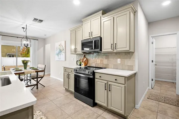 a kitchen with cabinets appliances and a window