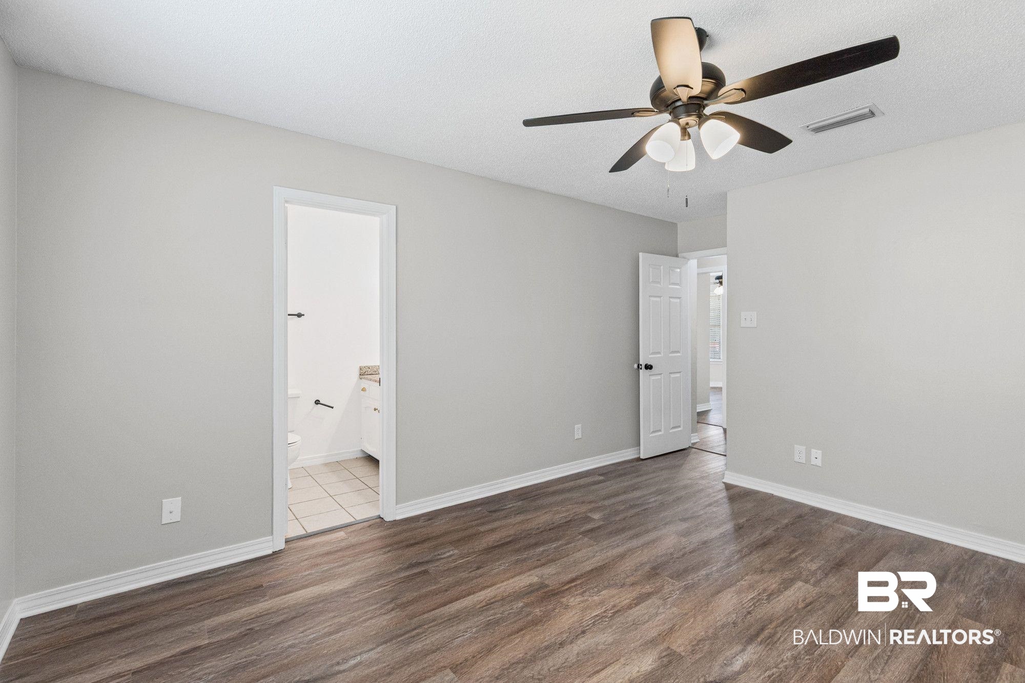 1301 Repoll Road Mobile, AL 36695 - Photo 17 of 21 Spacious room featuring wood-finish flooring, light grey painted walls, and white baseboards