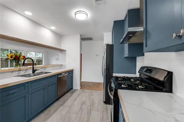 a kitchen with stainless steel appliances and refrigerator