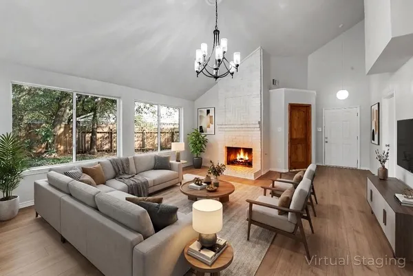 an empty room with wooden floor chandelier and windows