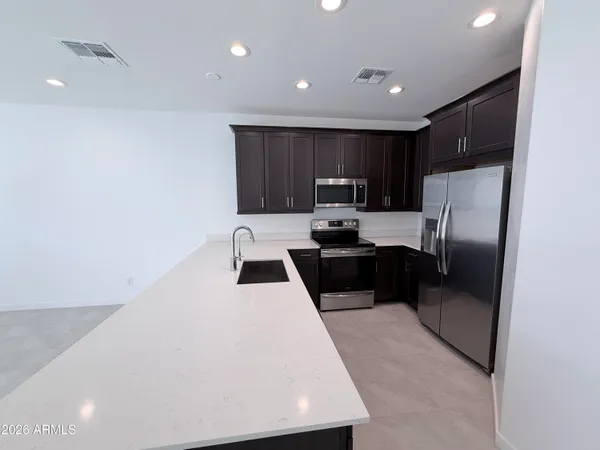 a kitchen with a refrigerator a stove and a sink