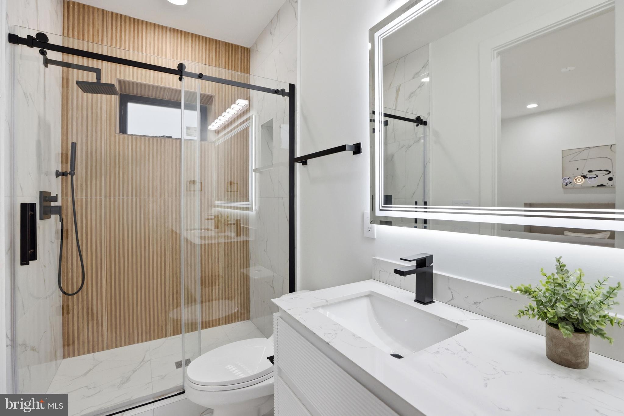 1140 Oates Street Northeast, Unit 101 Washington, DC 20002 - Photo 22 of 31 a bathroom with a sink toilet and shower