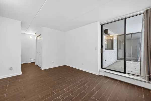 a view of empty room with wooden floor