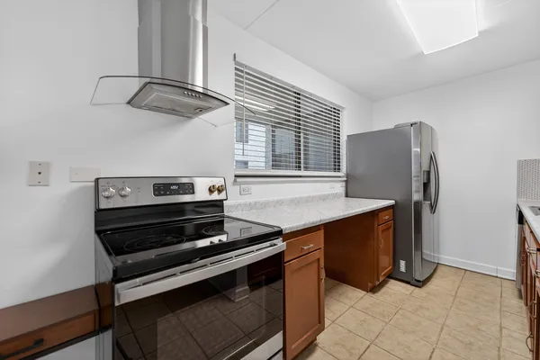 a kitchen with stainless steel appliances granite countertop a refrigerator and a stove top oven