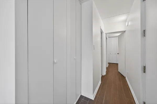 a view of a hallway with wooden floor