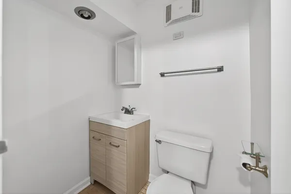 a bathroom with a toilet a sink and mirror