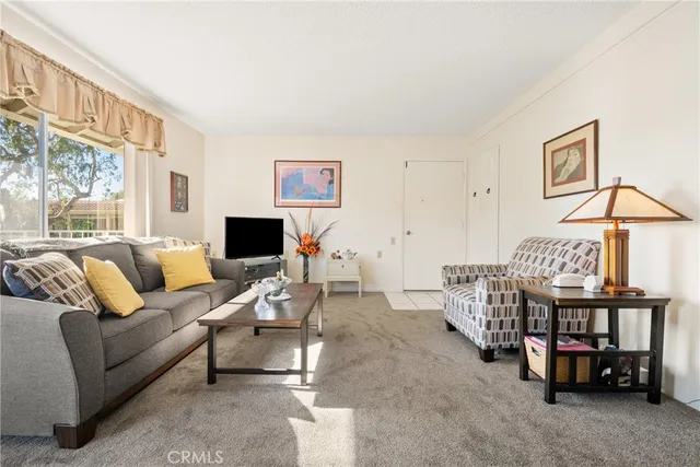 a living room with furniture a flat screen tv and a window