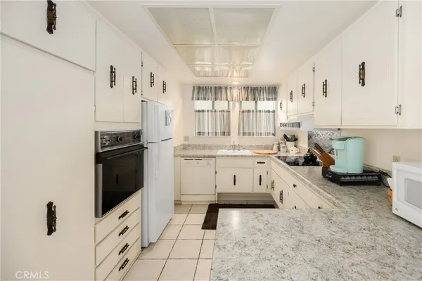 a kitchen with white cabinets and sink