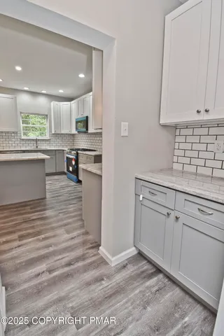 a view of a room with wooden floor and white walls