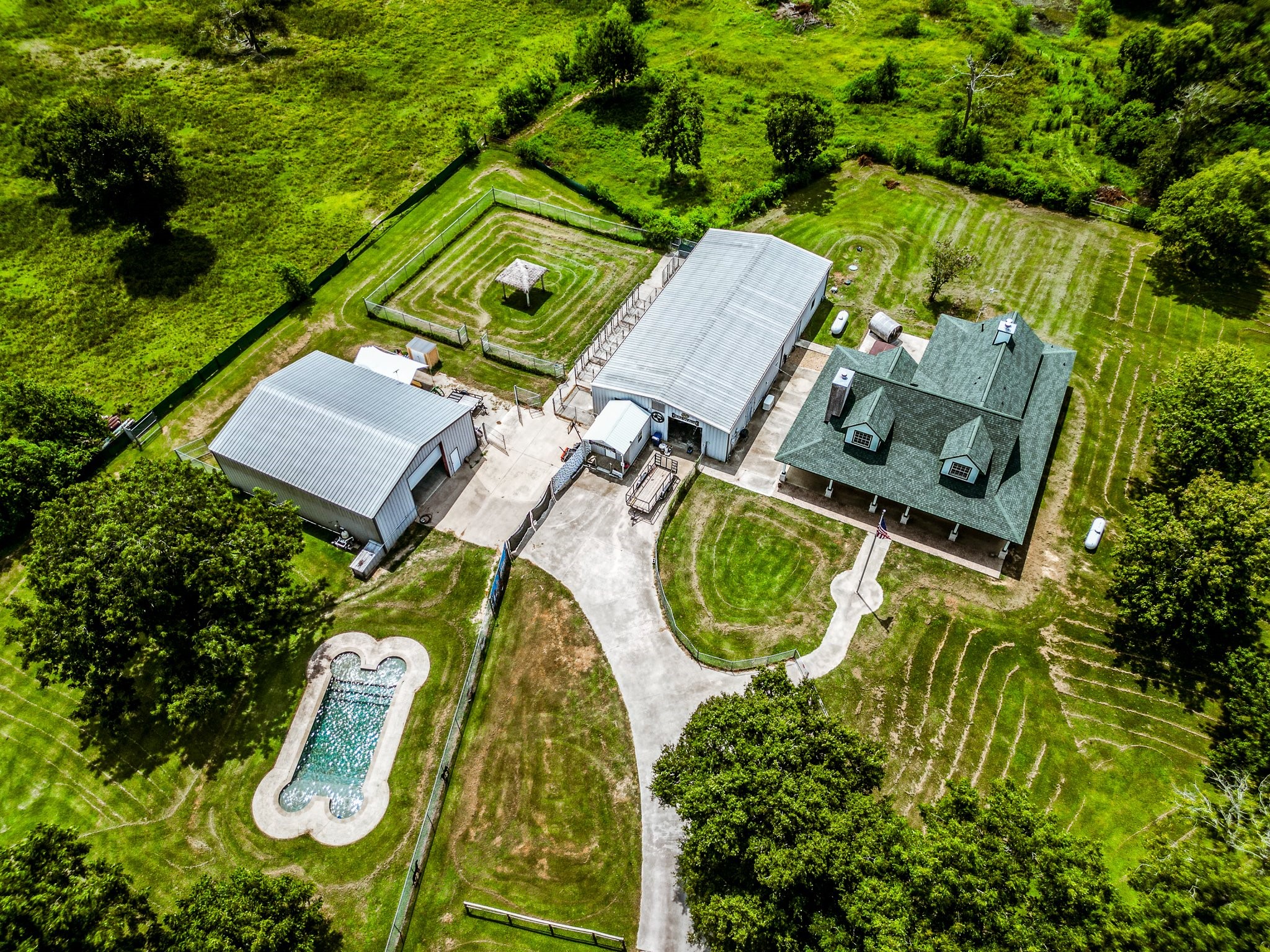 9010 Point Barrow Road Beach City, TX 77523 - Photo 2 of 50 A bird’s-eye view showcases the scale & versatility of the property, featuring the residence, pool, spa, private sauna, pond, 40'×80' shop & 40'×50' shop, all situated across 8.3 unrestricted acres.
