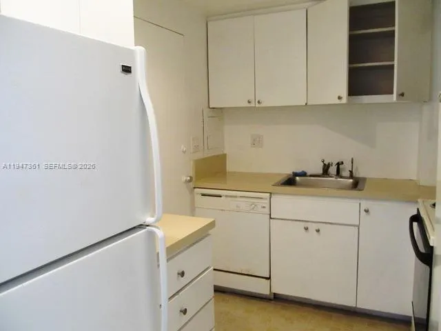 a kitchen with white cabinets and white appliances