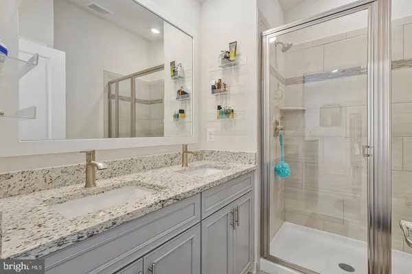 a bathroom with a granite countertop shower sink and mirror