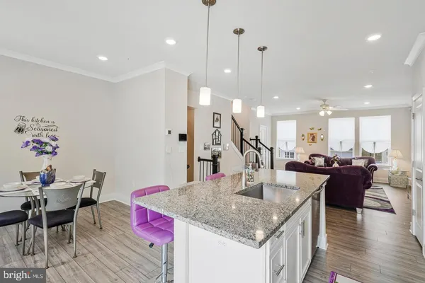 a kitchen with granite countertop kitchen island stainless steel appliances sink dining table and chairs