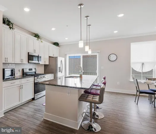 a kitchen with stainless steel appliances kitchen island granite countertop a stove a sink and a refrigerator