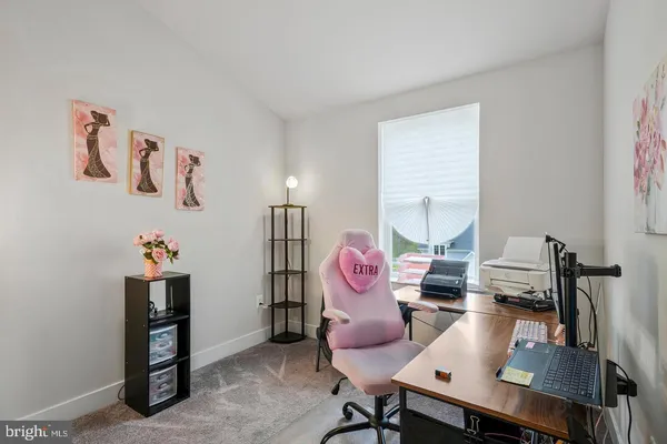 a view of a workspace with furniture and a window