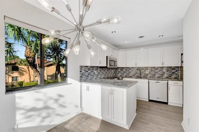 a kitchen with stainless steel appliances granite countertop a stove and a sink