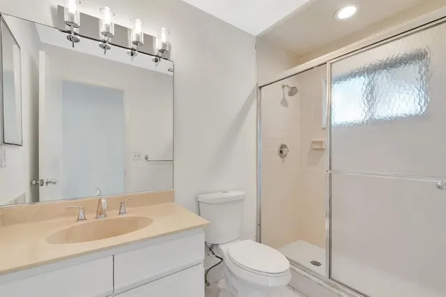 a view of an empty room with wooden floor and window