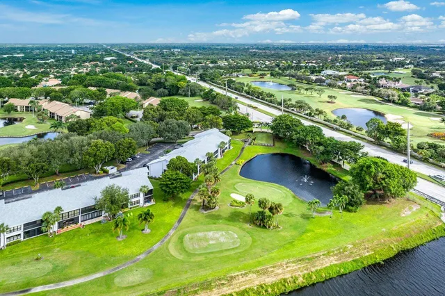 an aerial view of a swimming pool with a yard and outdoor seating