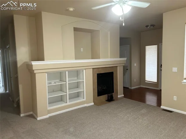 a view of an empty room with a fireplace and a window