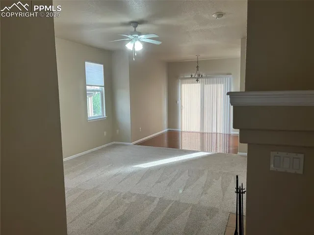 a view of a hallway with windows and chandelier