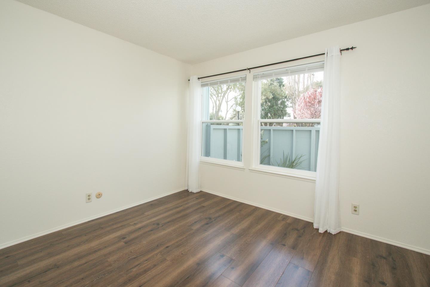 740 Pinta Lane Foster City, CA 94404 - Photo 17 of 33 an empty room with wooden floor and windows