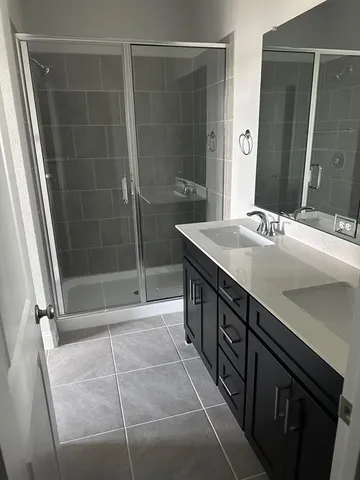 a bathroom with a shower sink and mirror