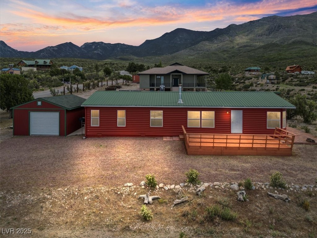 Rustic home featuring a mountain view, metal roof, and gravel driveway