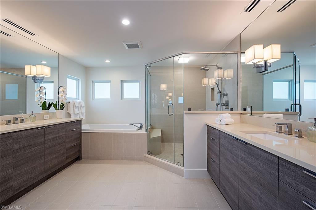 1600 Murex Lane Naples, FL 34102 - Photo 14 of 25 a bathroom with a double vanity sink a large mirror and shower