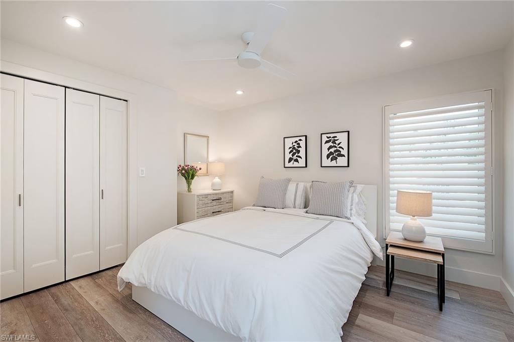 1600 Murex Lane Naples, FL 34102 - Photo 15 of 25 a bedroom with a large bed and a chandelier