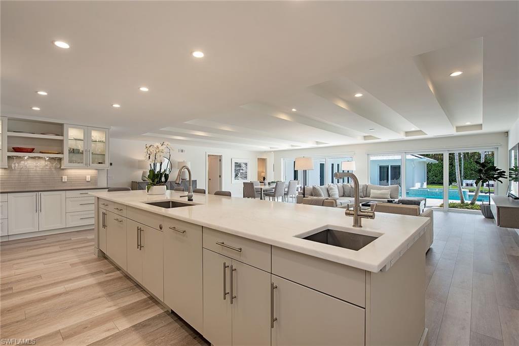 1600 Murex Lane Naples, FL 34102 - Photo 6 of 25 a kitchen with sink and white cabinets with wooden floor