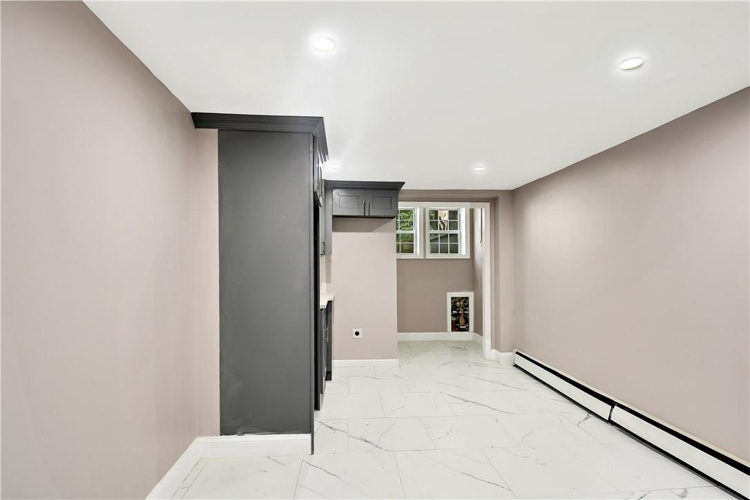 2726 Mickle Avenue Bronx, NY 10469 - Photo 10 of 16 a view of a hallway with wooden floor and a kitchen