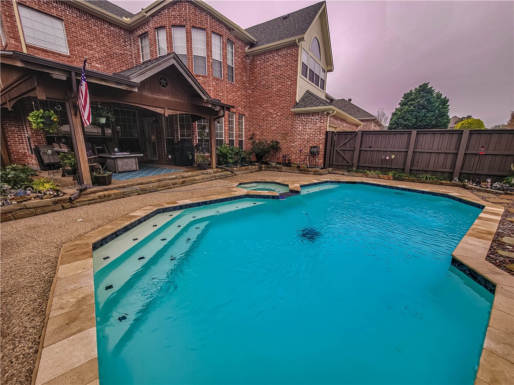 a view of swimming pool with lawn chairs and plants
