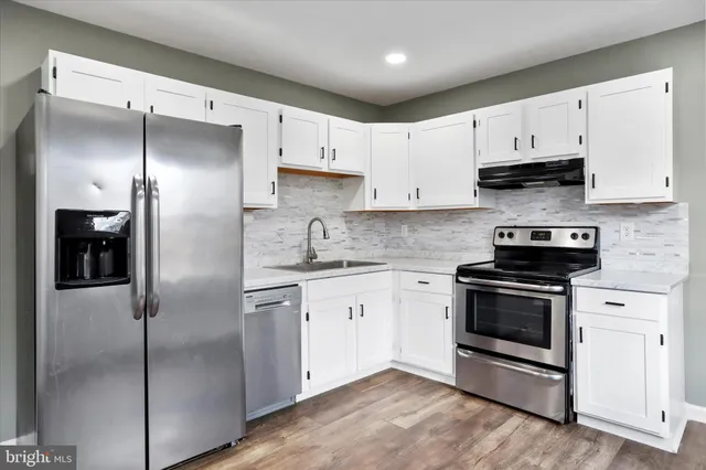 a kitchen with cabinets stainless steel appliances and a counter space