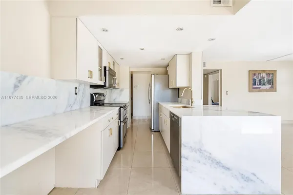 a large white kitchen with stainless steel appliances