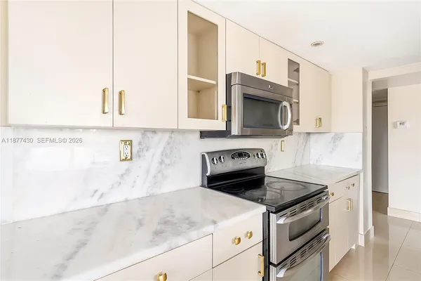 a kitchen with granite countertop a stove sink and microwave