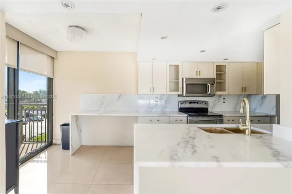 a kitchen with stainless steel appliances a sink a stove a microwave a sink and cabinets