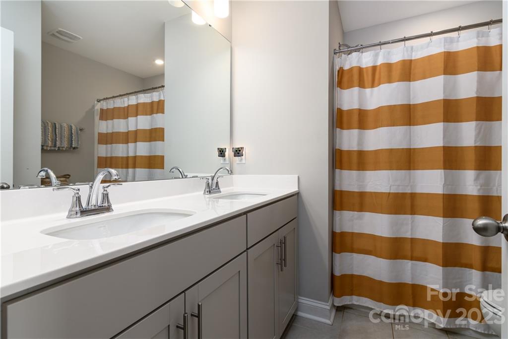 2036 Suttonview Road Fort Mill, SC 29708 - Photo 19 of 37 a bathroom with a sink a large mirror and a shower
