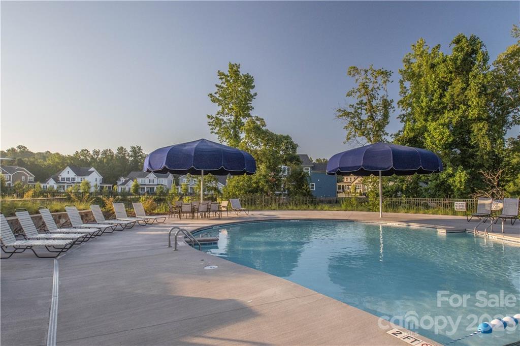 2036 Suttonview Road Fort Mill, SC 29708 - Photo 31 of 37 a view of a swimming pool with a table and chairs under an umbrella