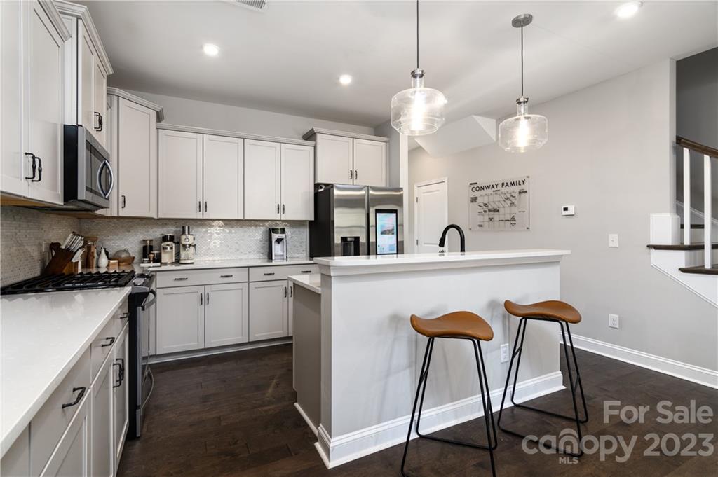 2036 Suttonview Road Fort Mill, SC 29708 - Photo 7 of 37 a kitchen with stainless steel appliances granite countertop a refrigerator a sink dishwasher a dining table and chairs with wooden floor