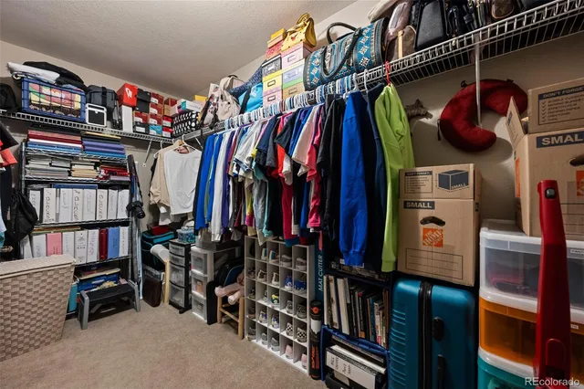 a view of walk in closet with clothes and shoes