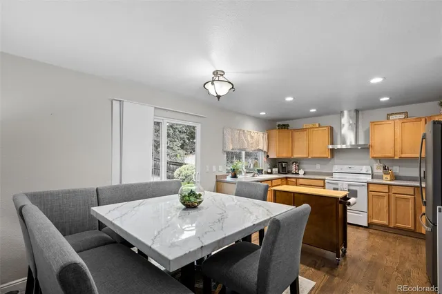 a kitchen with a dining table chairs and refrigerator