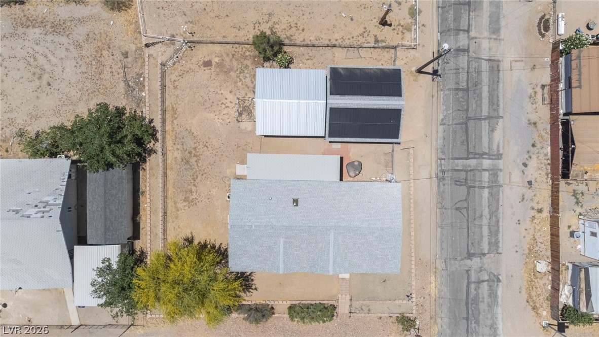225 California Street Searchlight, NV 89046 - Photo 58 of 64 An aerial perspective reveals a residence with solar energy installations, set within a vast, undeveloped lot.