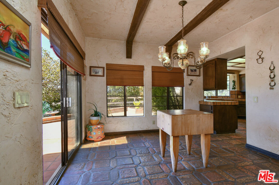 24926 Jim Bridger Road Hidden Hills, CA 91302 - Photo 16 of 40 a dining room with wooden floor and chandelier