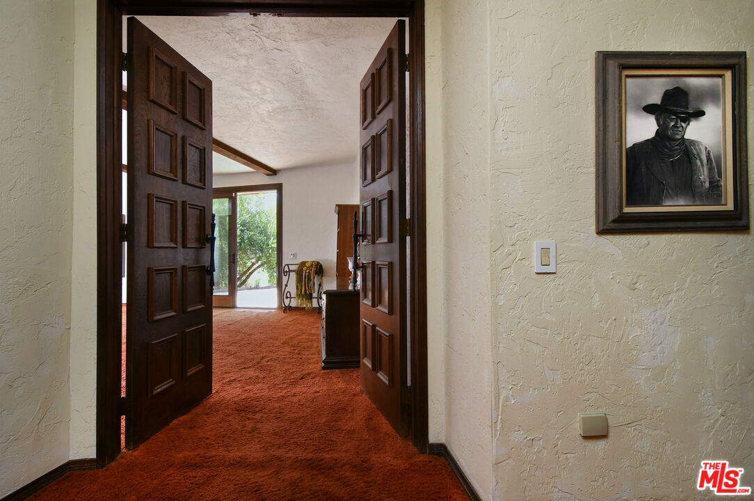 24926 Jim Bridger Road Hidden Hills, CA 91302 - Photo 21 of 44 a view of hallway with living room and furniture