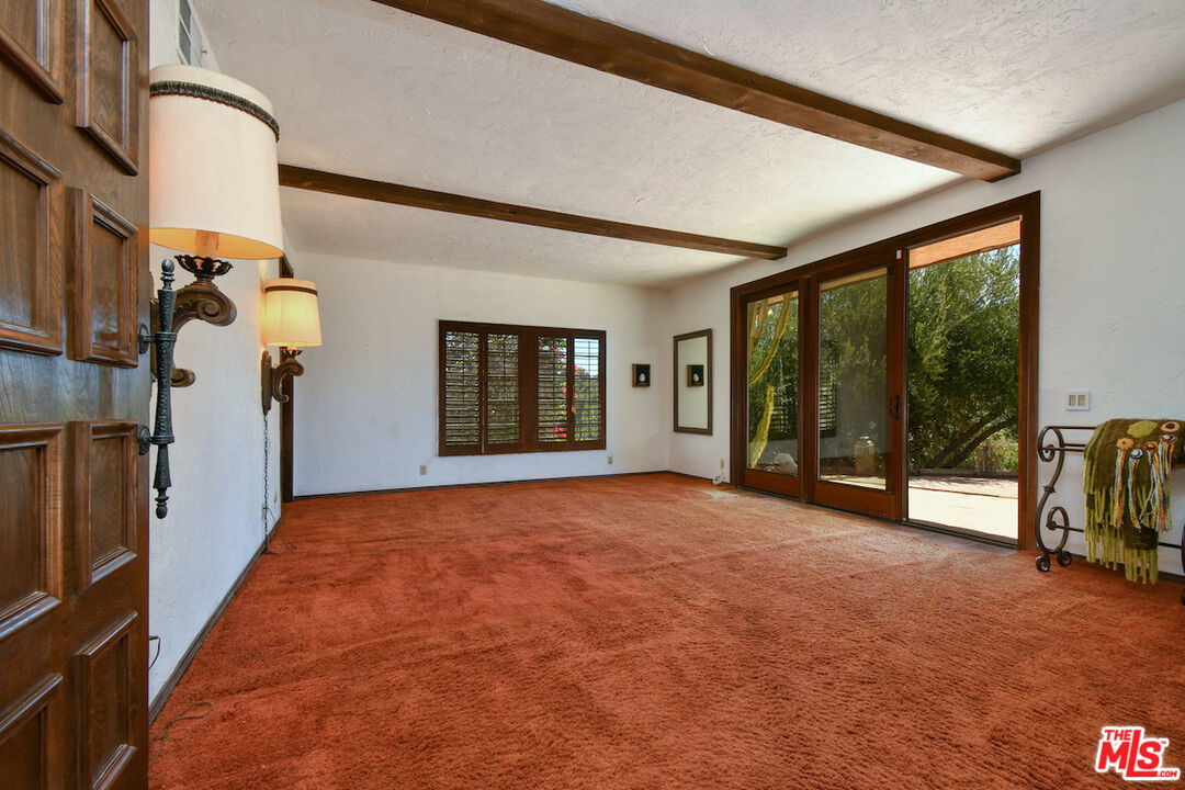 24926 Jim Bridger Road Hidden Hills, CA 91302 - Photo 23 of 40 a view of an empty room with stairs and a large window