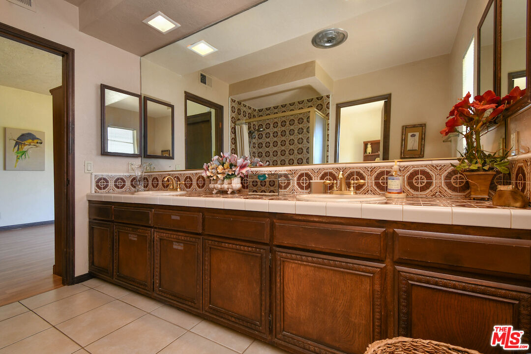 24926 Jim Bridger Road Hidden Hills, CA 91302 - Photo 28 of 44 a bathroom with a sink and a mirror